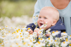 cute-baby-with-flowers-chamomile-field-mother-holding-child-walking-wild-flowers-meadow